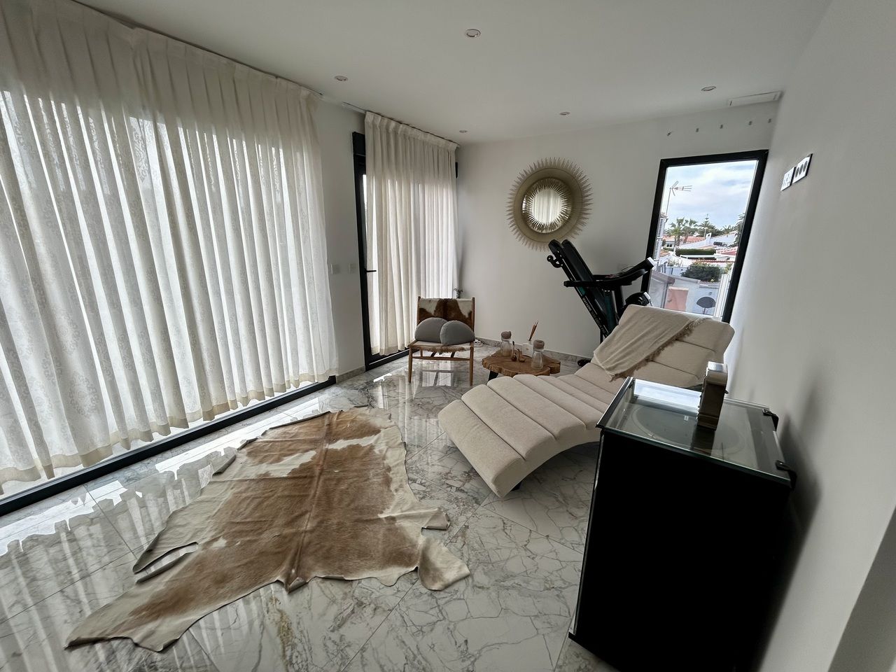 Lichte, moderne interieur met chaise longue en decoratieve elementen.