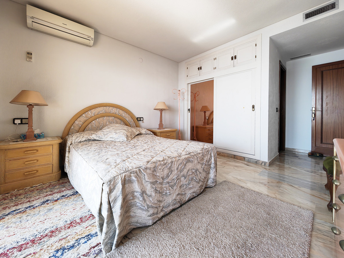 Gezellige slaapkamer met bed, nachtkastjes en inbouwkast.