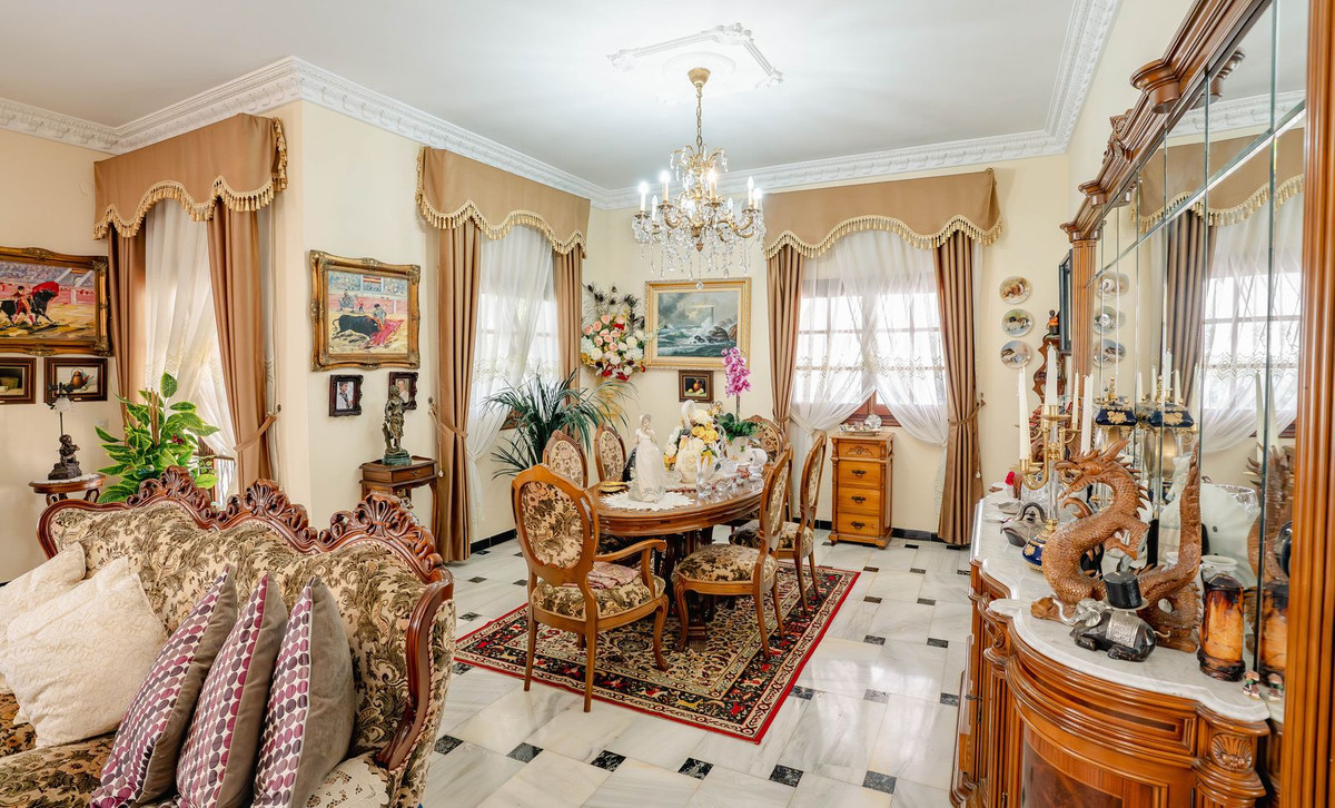 Rijkelijk versierde eet- en woonkamer met antieke meubels en decoratieve objecten.