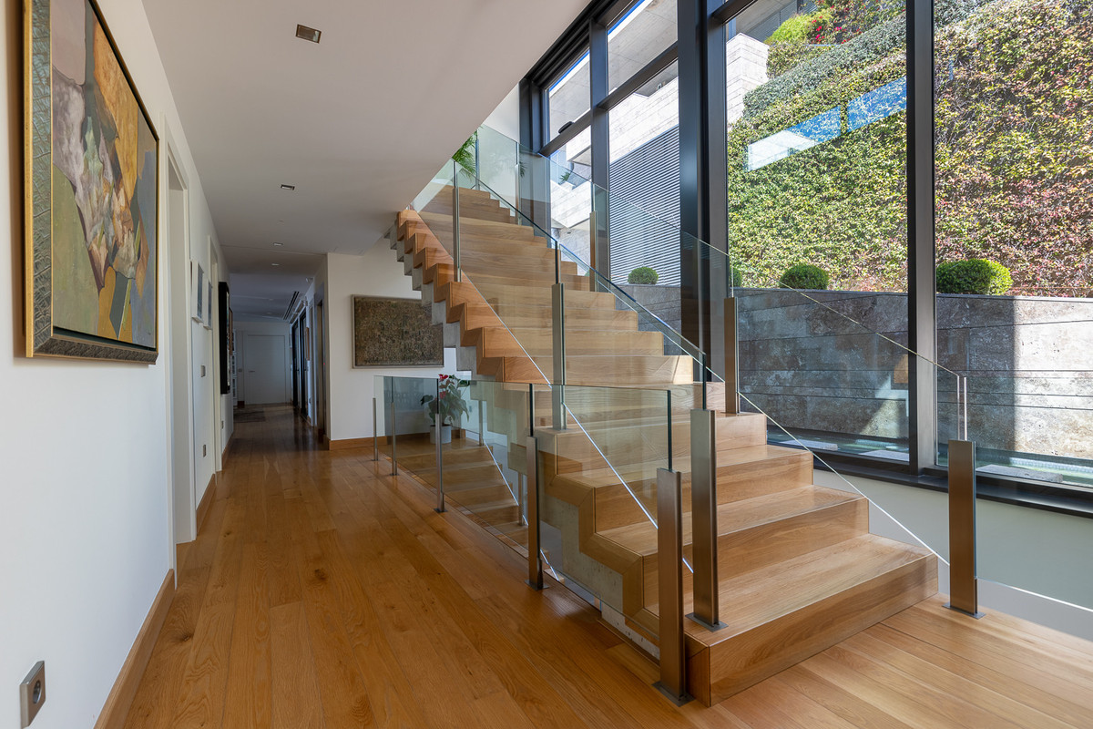 Moderne trap met glazen balustrade in hal met kunstwerken
