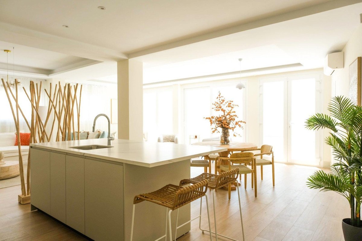 Modern kitchen with island, large windows, and dining area.