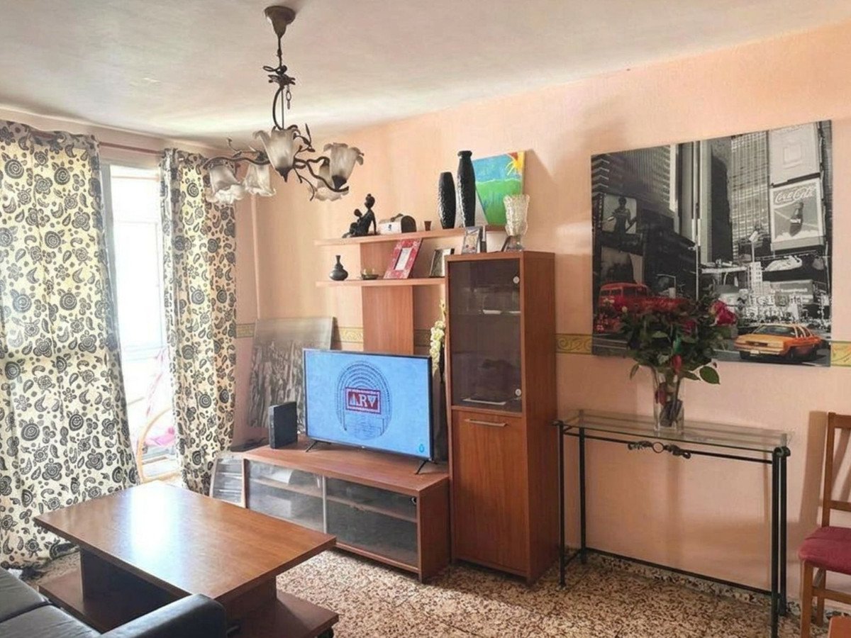 Living room with television, wooden furniture, and cityscape artwork