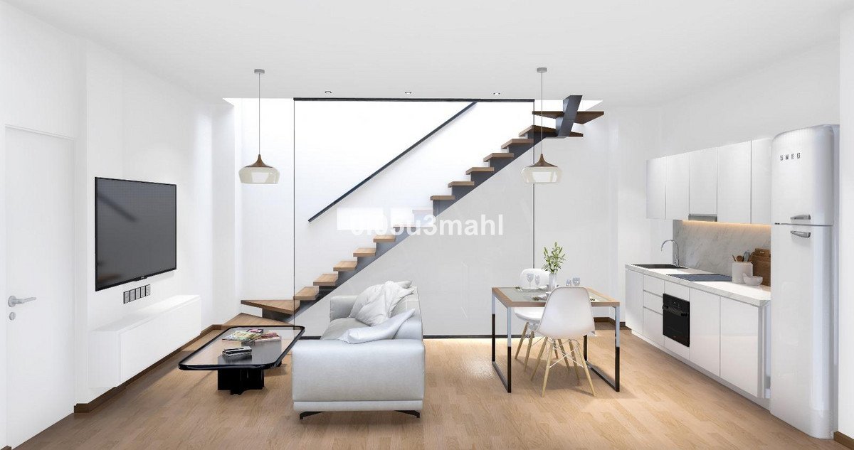 Open-plan living area with modern kitchen, sofa, dining table, and contemporary staircase.