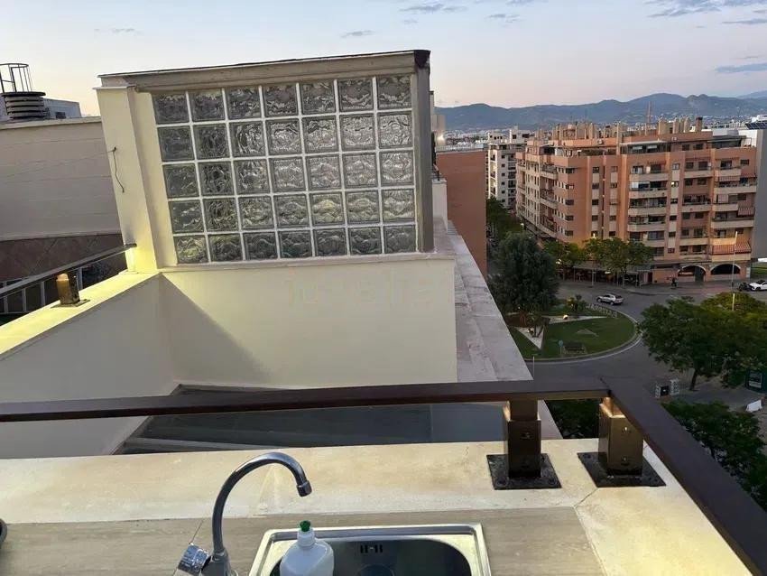 Outdoor sink on a terrace with a view of buildings and mountains in the distance.