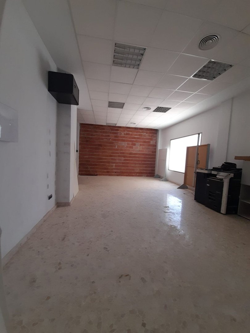 Tühi büroopind tellisseina, valge lae ja suure aknaga.