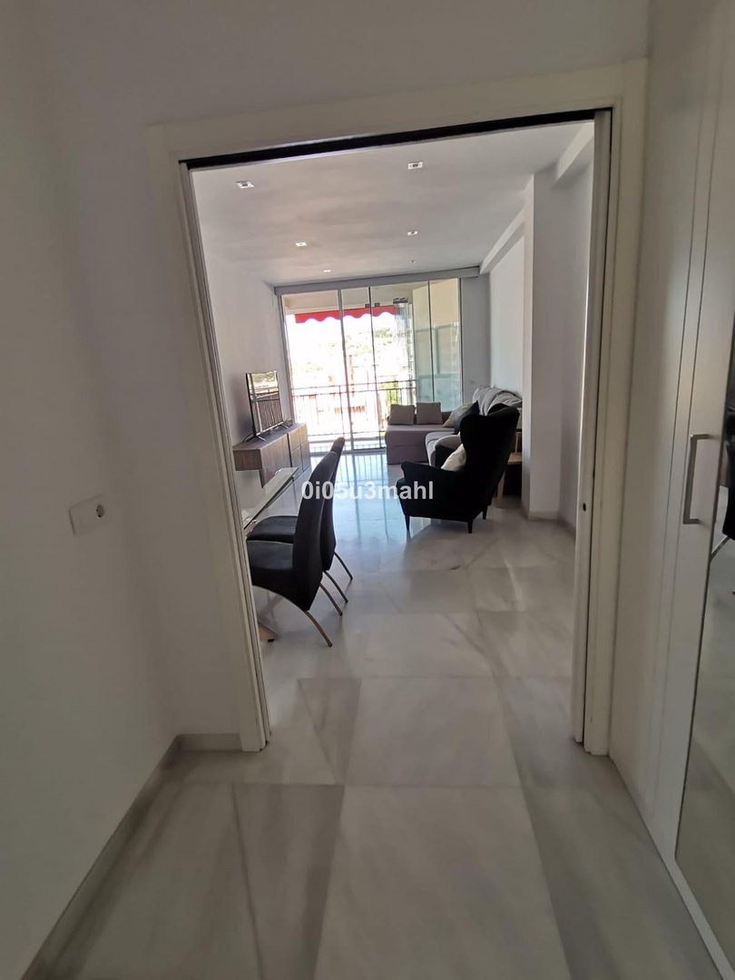Modern living room with balcony access, comfortable seating, and a TV console.