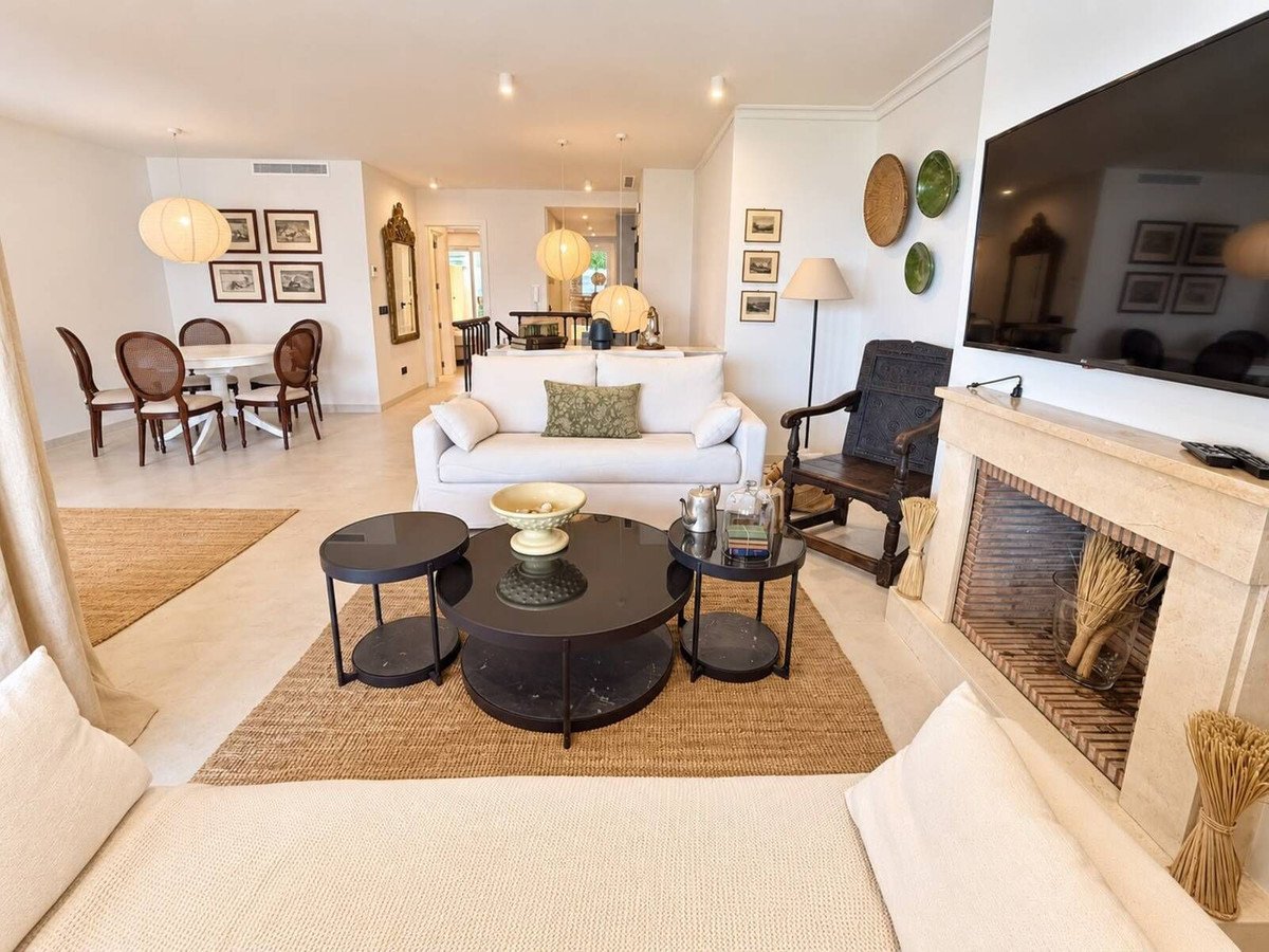 Spacious living and dining area with a fireplace, comfortable sofa, and dining table.