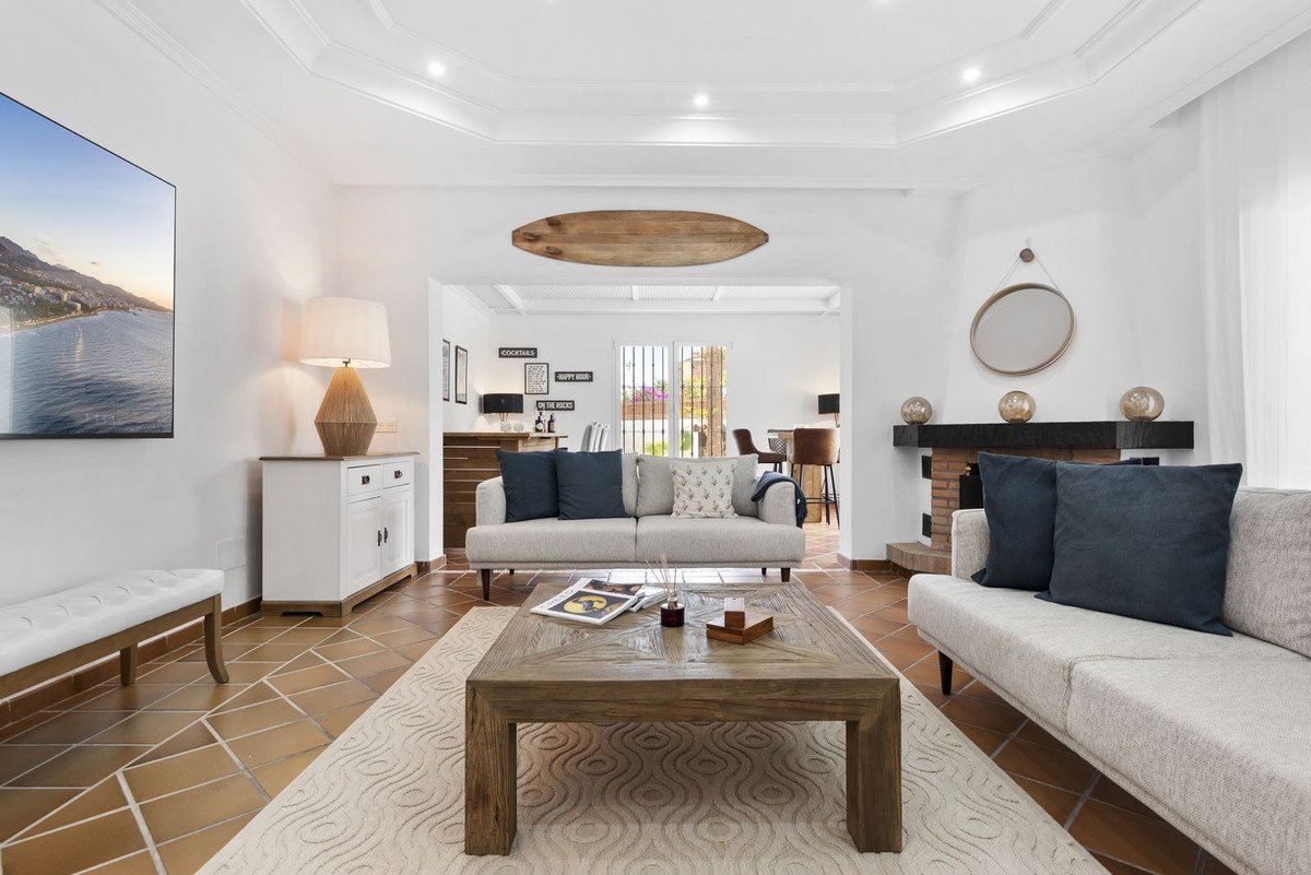 Modern living room with beige sofas, wooden coffee table, and large sea view painting