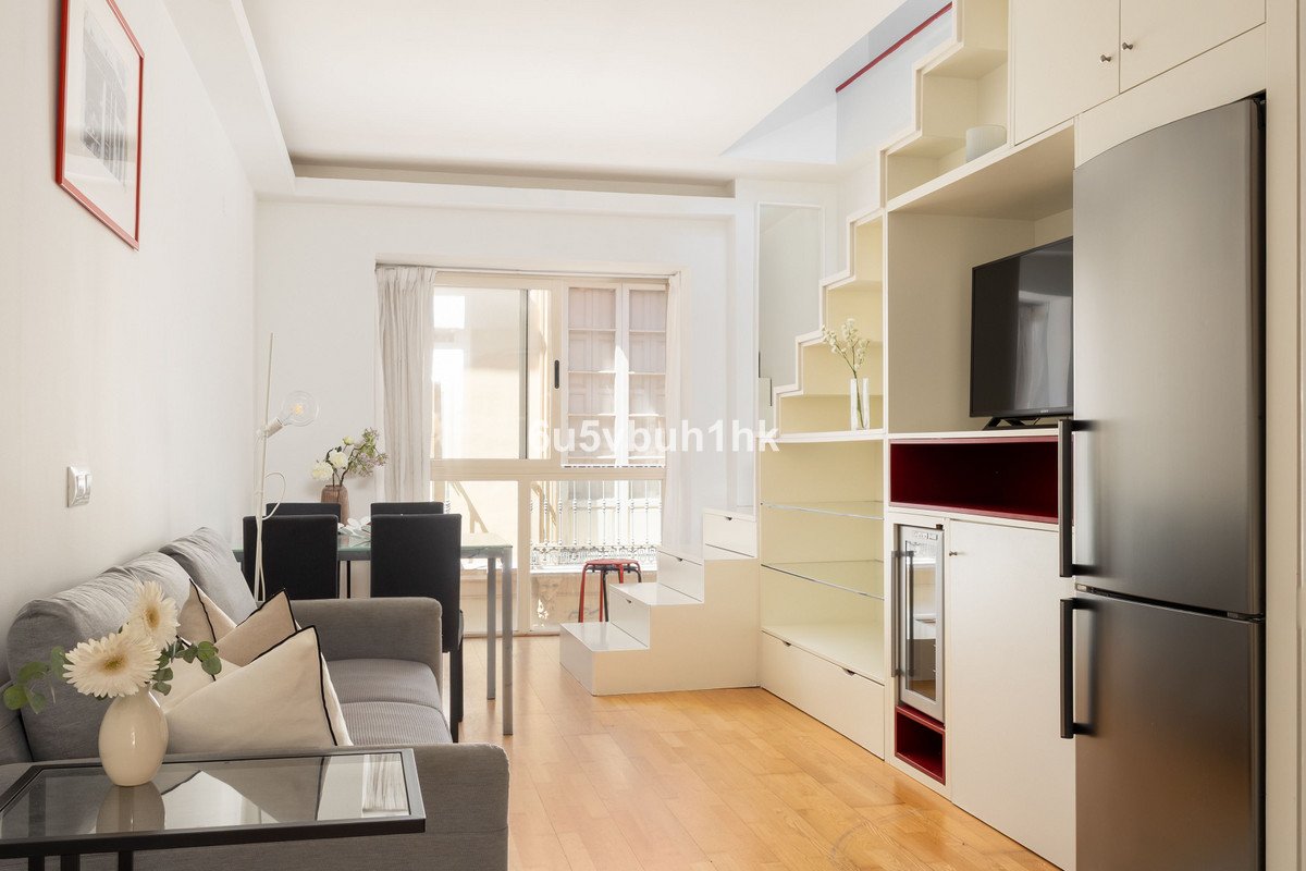 Modern living and dining area with built-in smart storage solutions, sofa, dining table, and a view of a window.