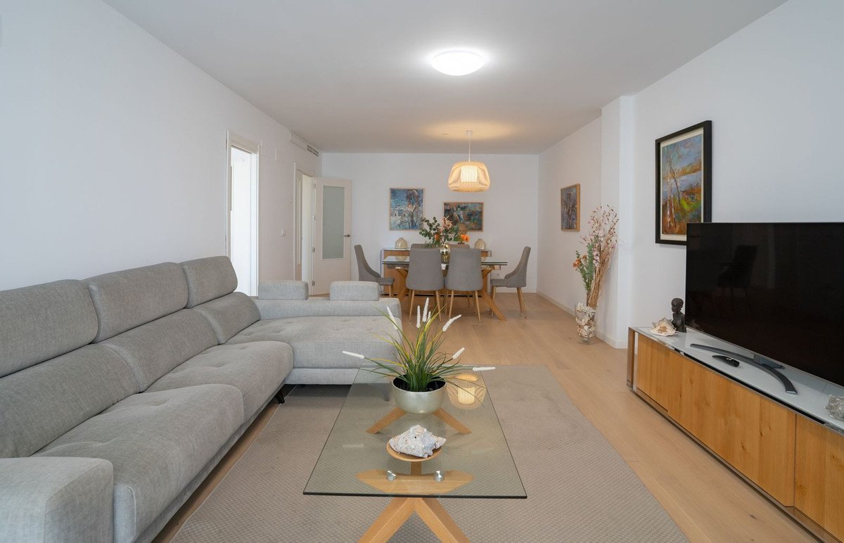 Modern living and dining room with a large sectional sofa, glass coffee table, and a dining set.