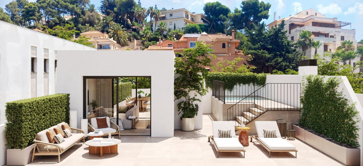 Modern terrace with lounge seating, dining area visible through glass doors, and a small plunge pool overlooking a lush, hilly landscape.
