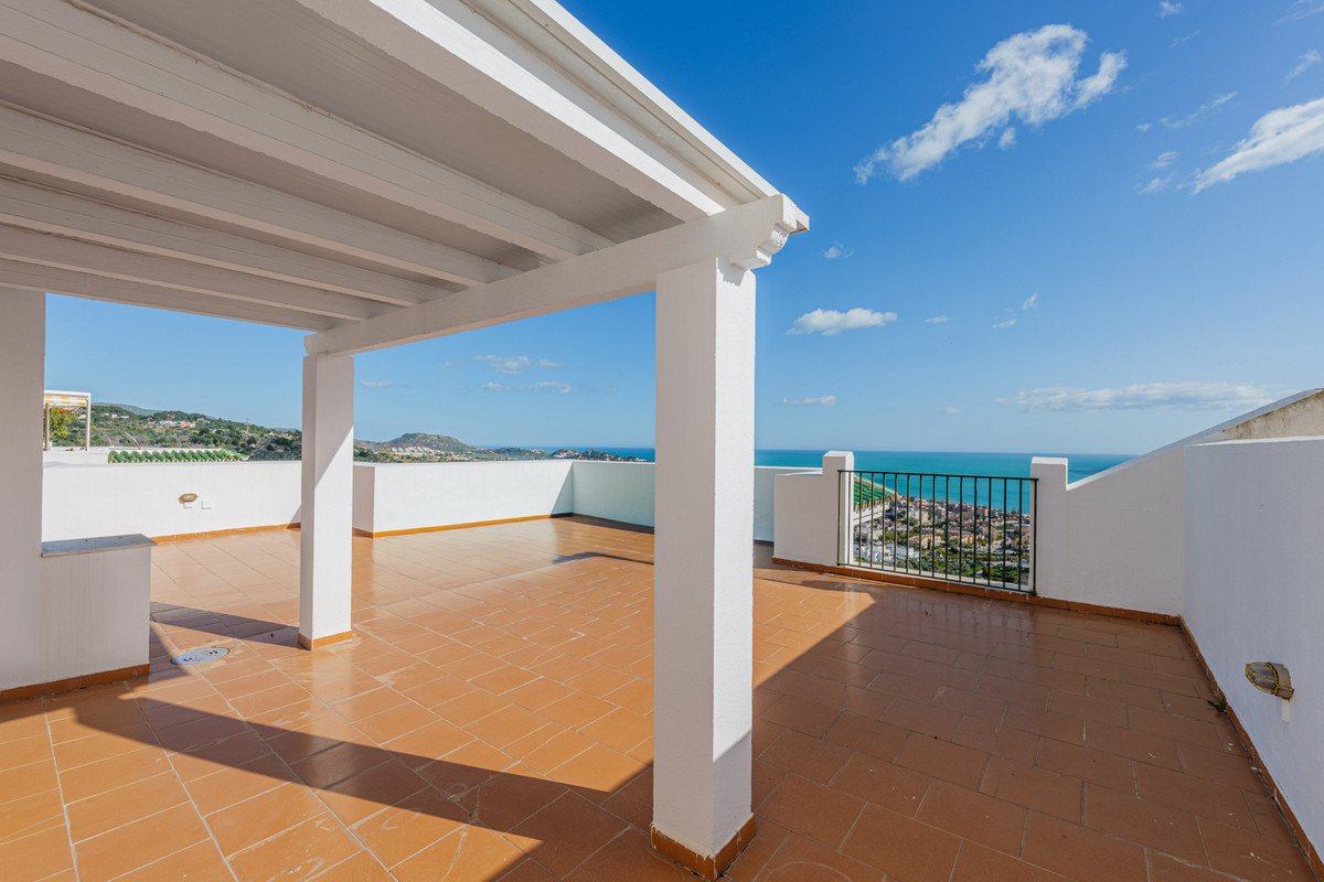 Spacious terrace with a white pergola, offering a panoramic view of the sea and town.