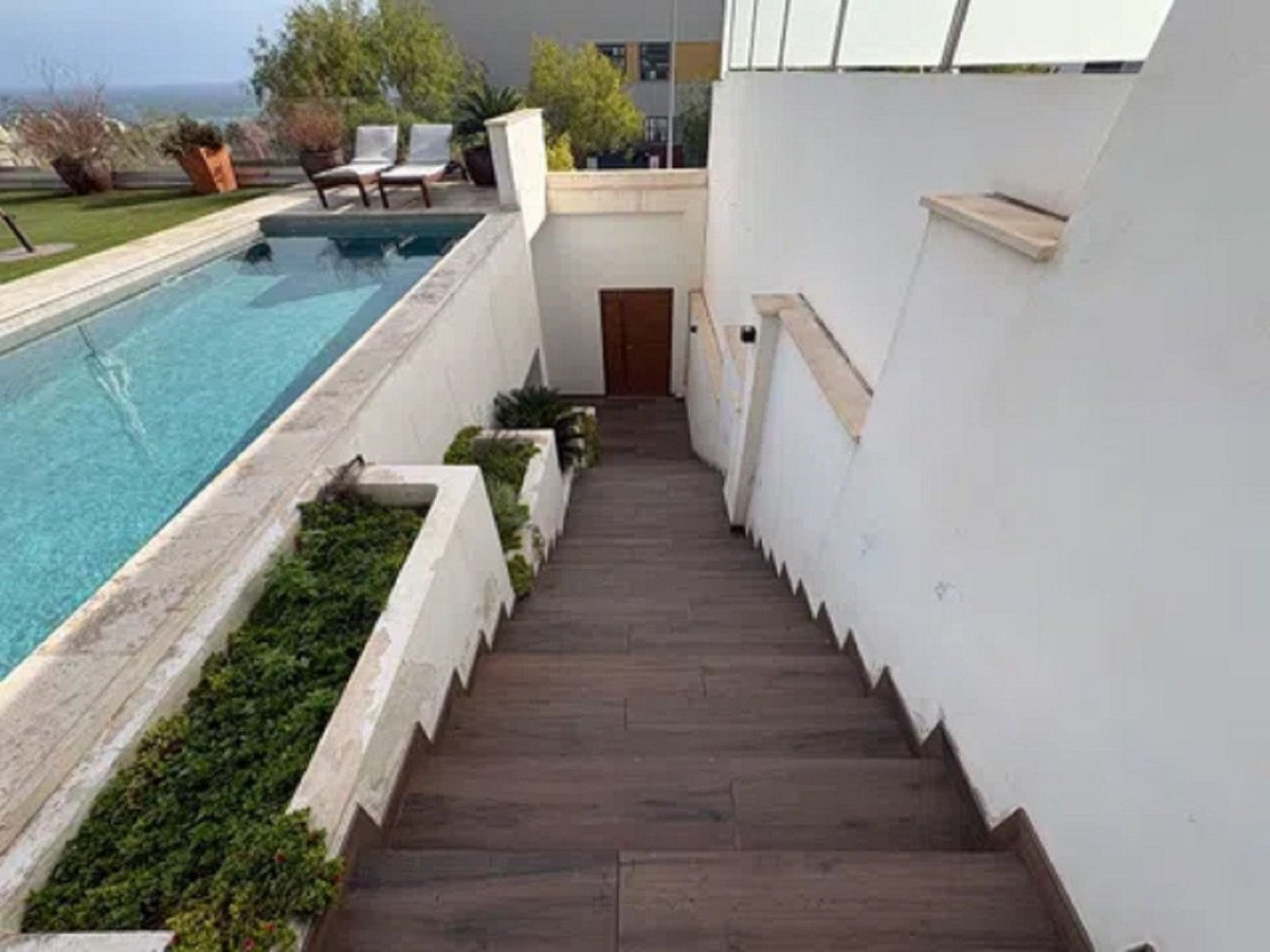 Modern outdoor staircase with pool, lounge chairs, and scenic view