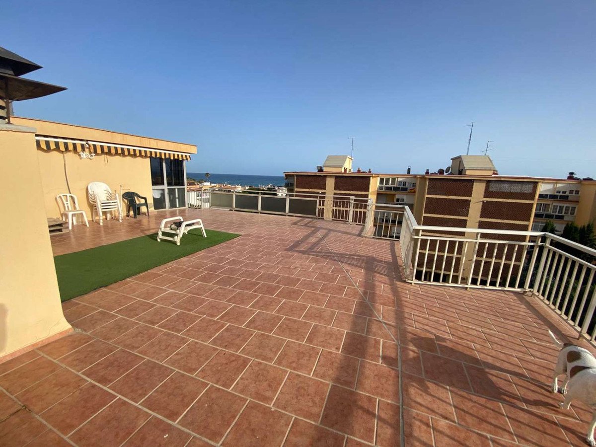 Balcony with tiled flooring, sea view, and a white dog