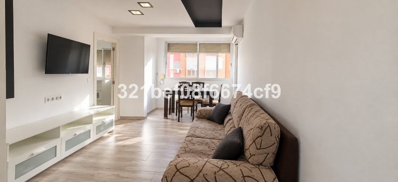 Modern living room with sofa, TV, and open-plan dining area