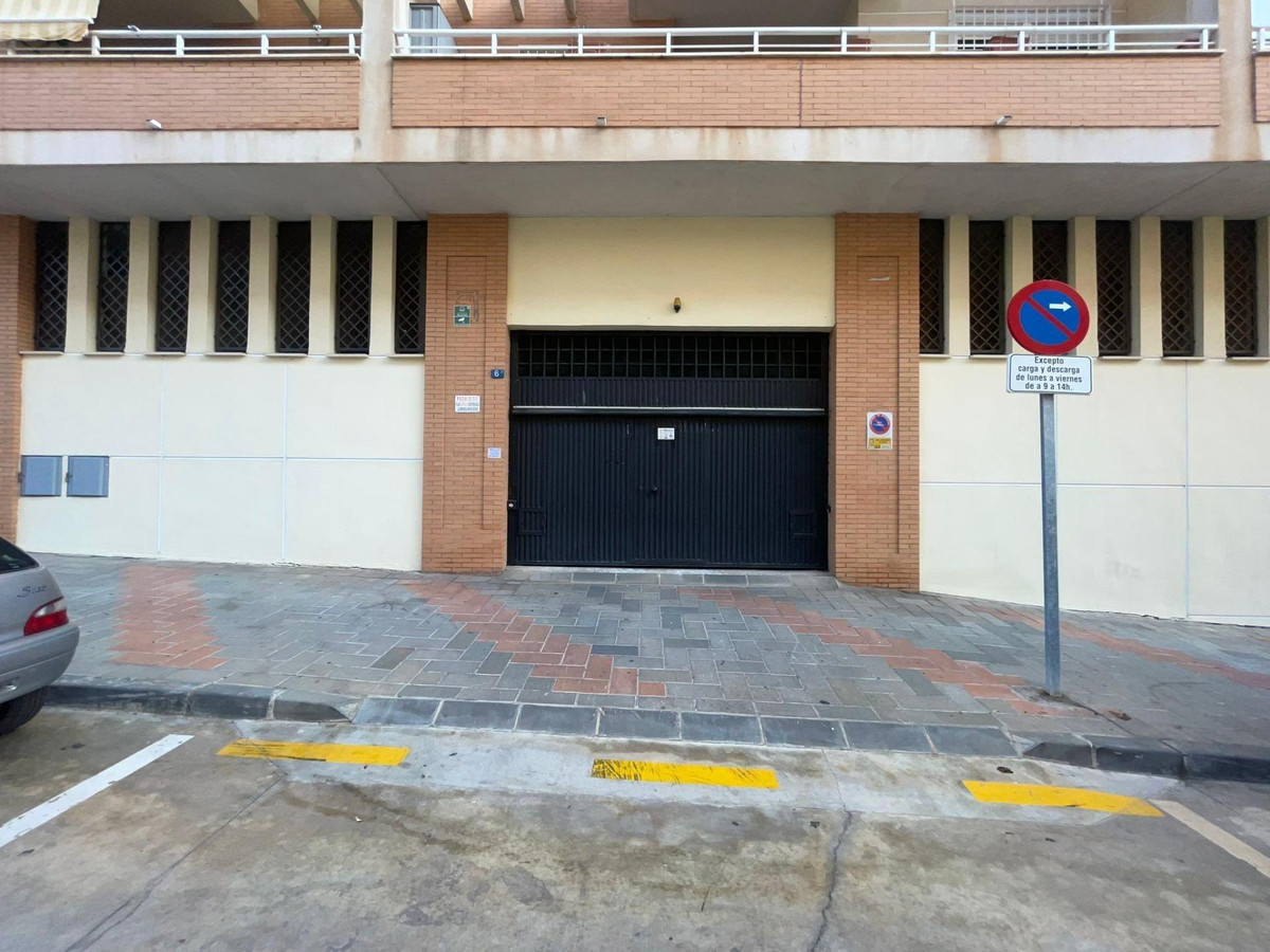 Gevel van gebouw met garagepoort en verkeersbord