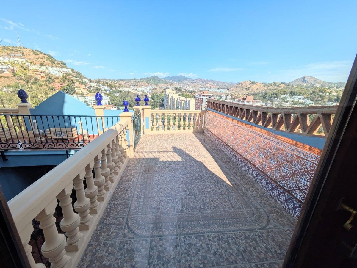 Balcony with city and mountain view, featuring ornate tile work and decorative railings.
