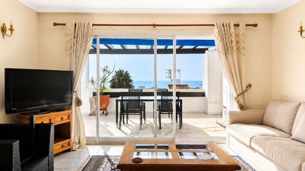 Living room with sea view and outdoor patio seating area