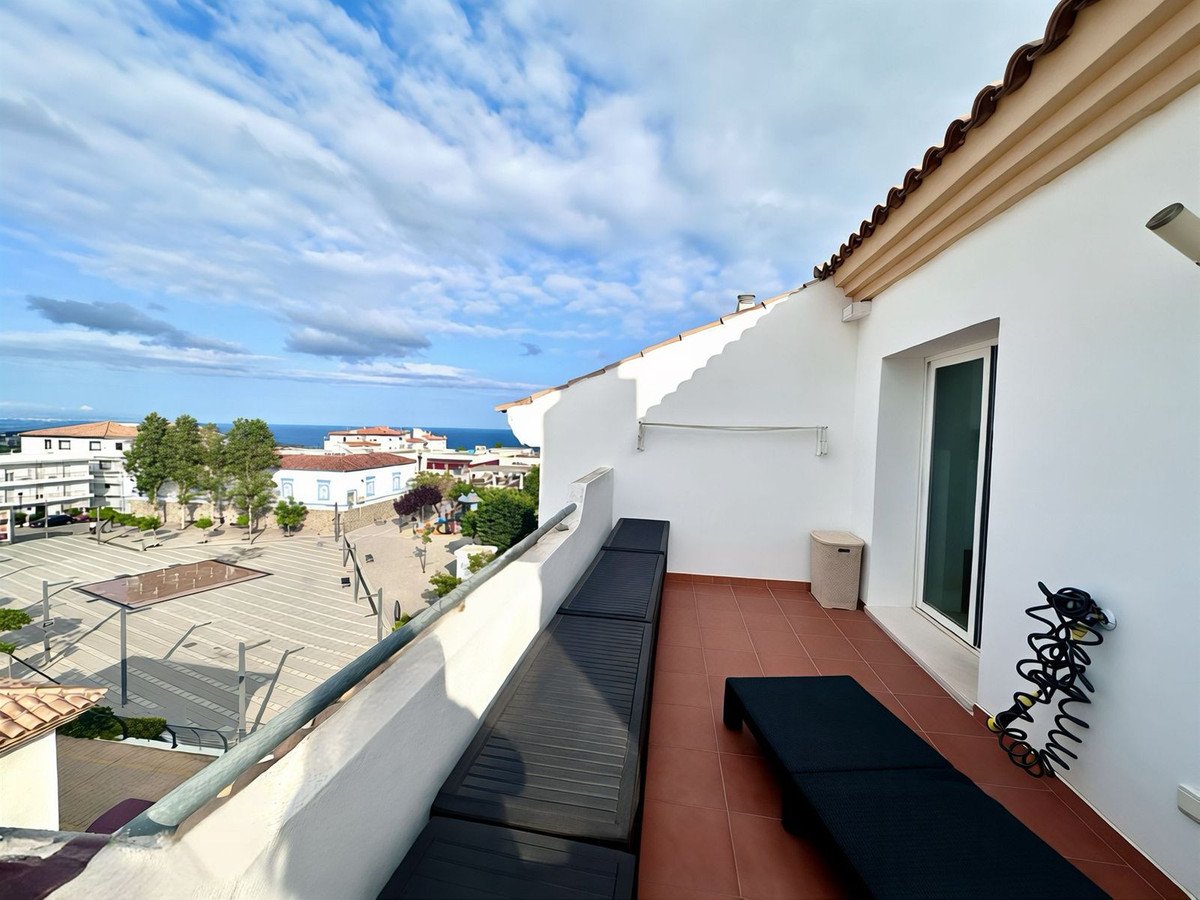 Balcony with tiled flooring overlooking a coastal town and sea