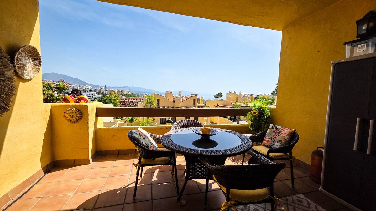 Yellow-walled terrace with table and scenic view of town and mountains