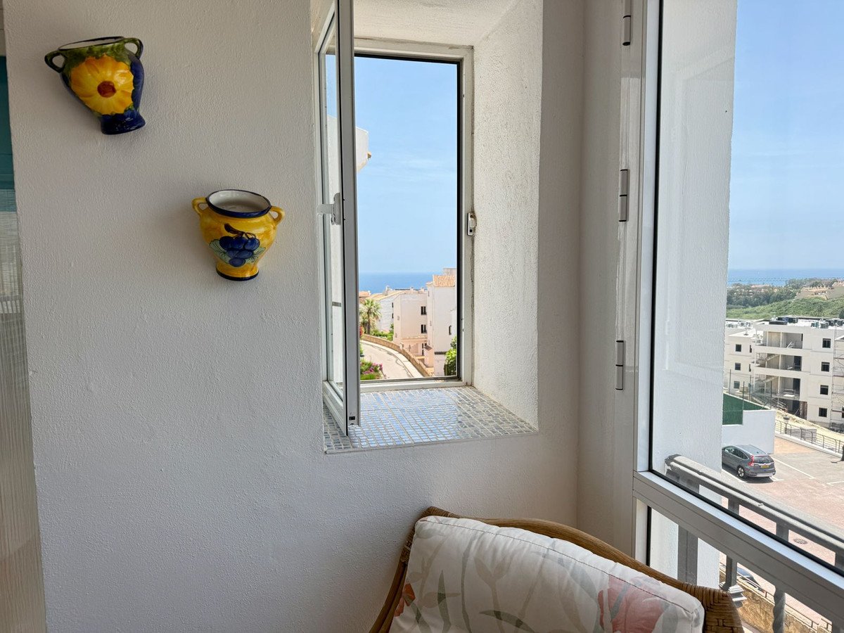 Balkon mit Korbstuhl, Keramikwandvasen, Meerblick vom offenen Fenster.