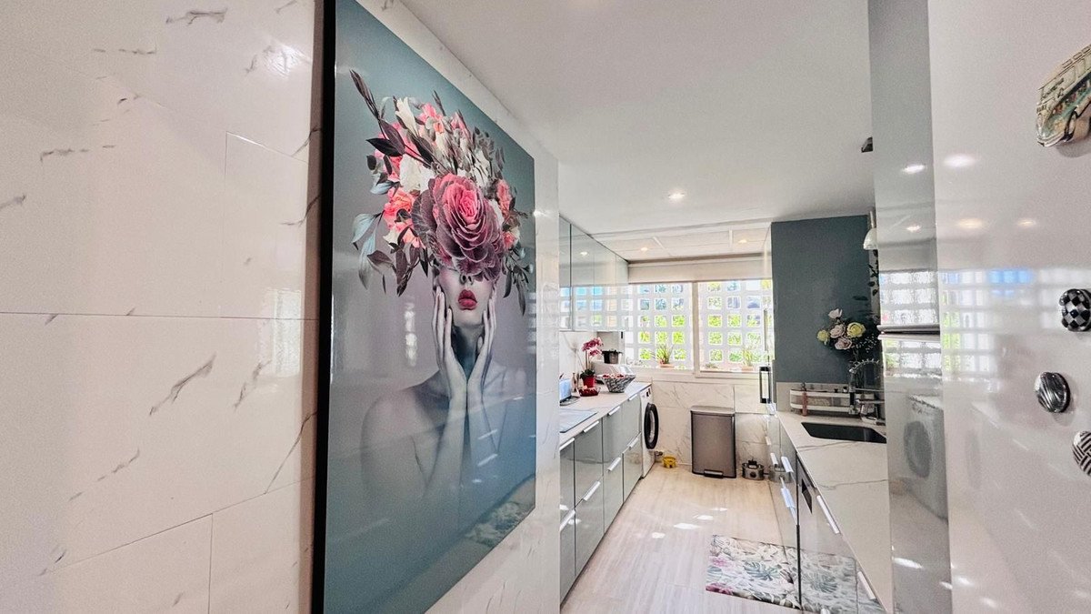 Modern kitchen featuring a large floral artwork on the wall and sleek cabinetry