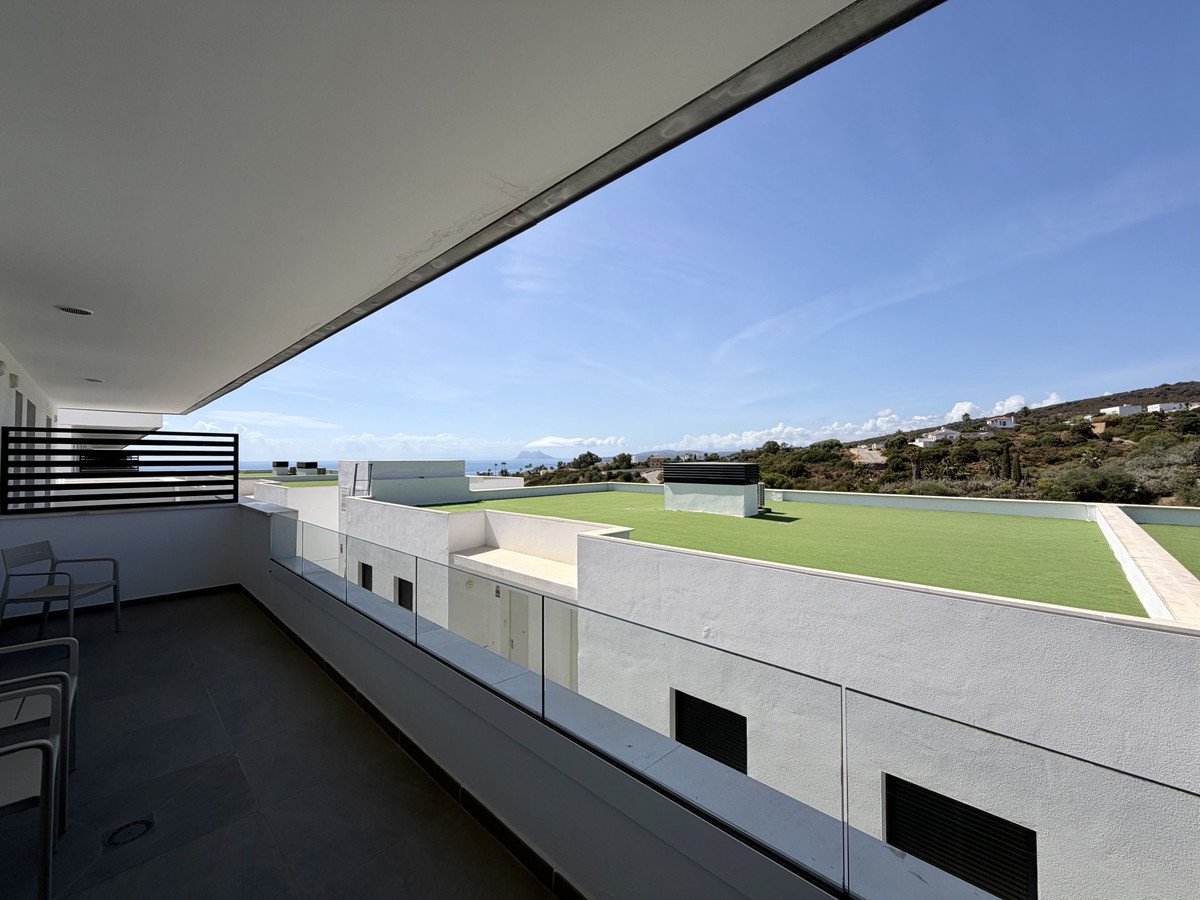 Modern balcony with sea view and artificial grass rooftop on a sunny day.