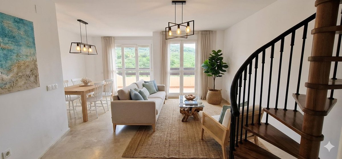 Modern living room with beige sofa, dining table, and large windows overlooking greenery