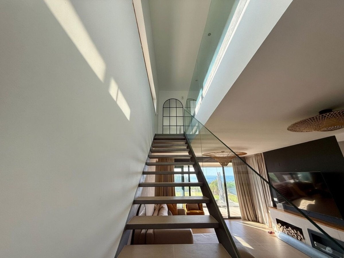 Modern living room with sleek staircase and ocean view