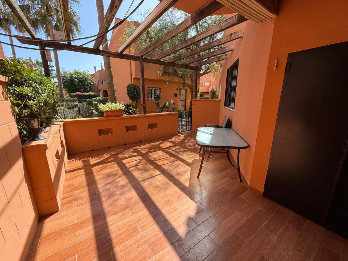 Terrace with wooden table, palm trees, and orange walls