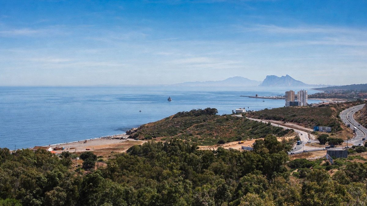 Coastal view with beach, sea, and distant mountains