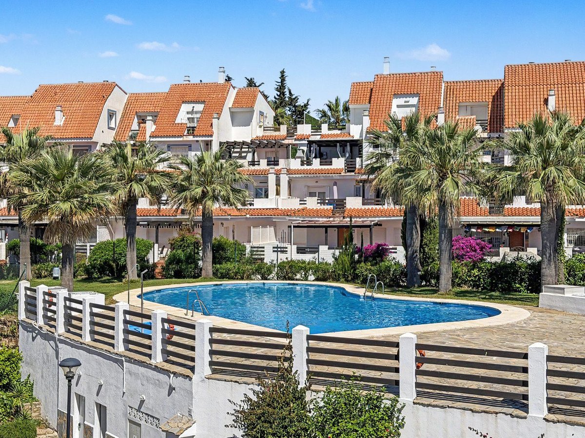 Luxurious swimming pool surrounded by palm trees and terracotta-roofed houses