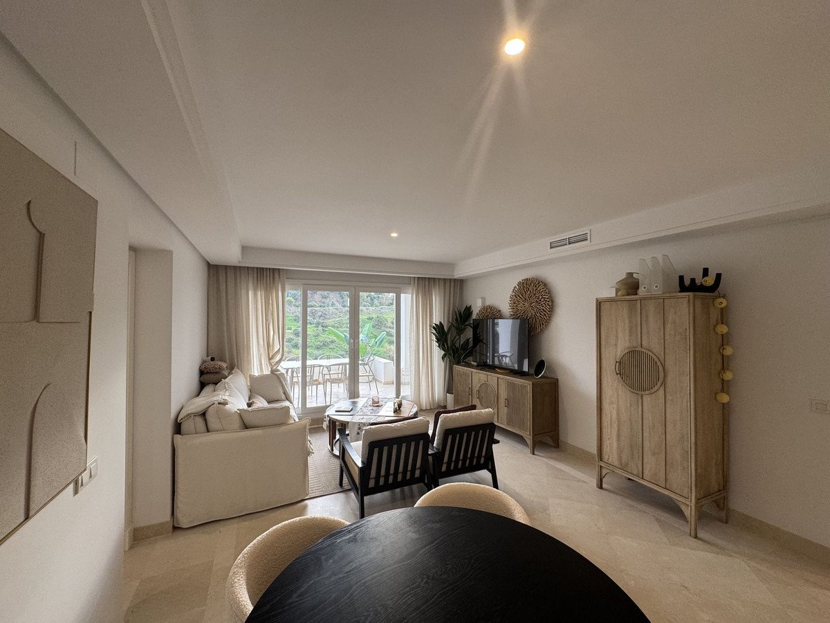 Moderní obývací pokoj s výhledem na balkon, jídelním stolem a pohodlným sezením.