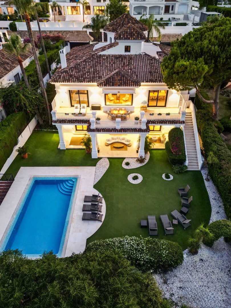Luxurious two-story home with tiled roof, swimming pool, and landscaped garden