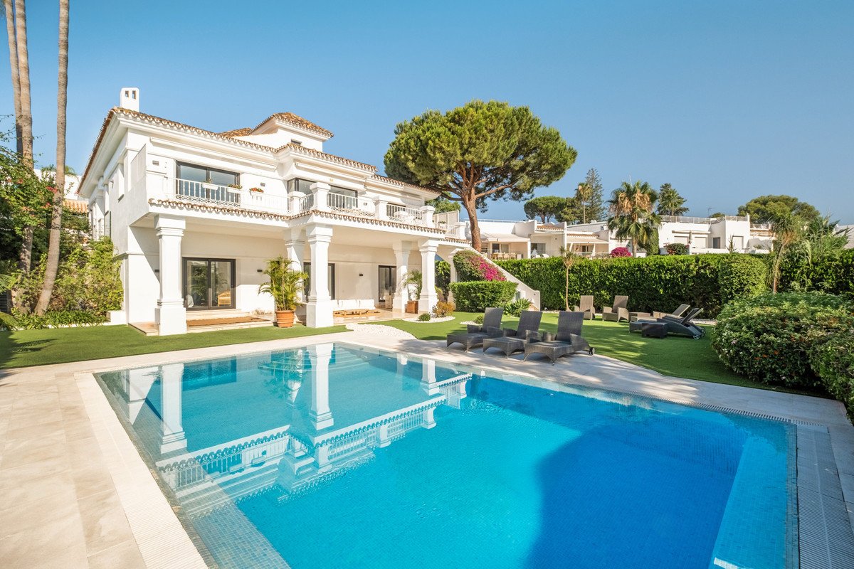 Luxurious white house with swimming pool and outdoor lounge area