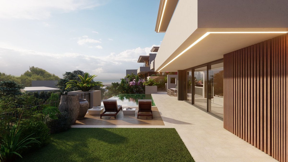 Modern villa with infinity pool, sun loungers, and a lush garden overlooking the ocean.