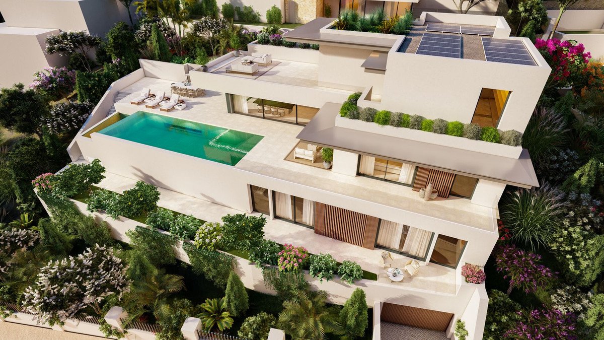 A modern villa with a swimming pool, lounge chairs on the terrace, and lush landscaping surrounding the property.