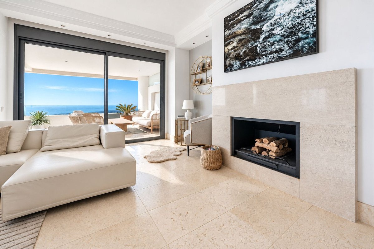 Modern living room with ocean view, fireplace, and sliding glass doors