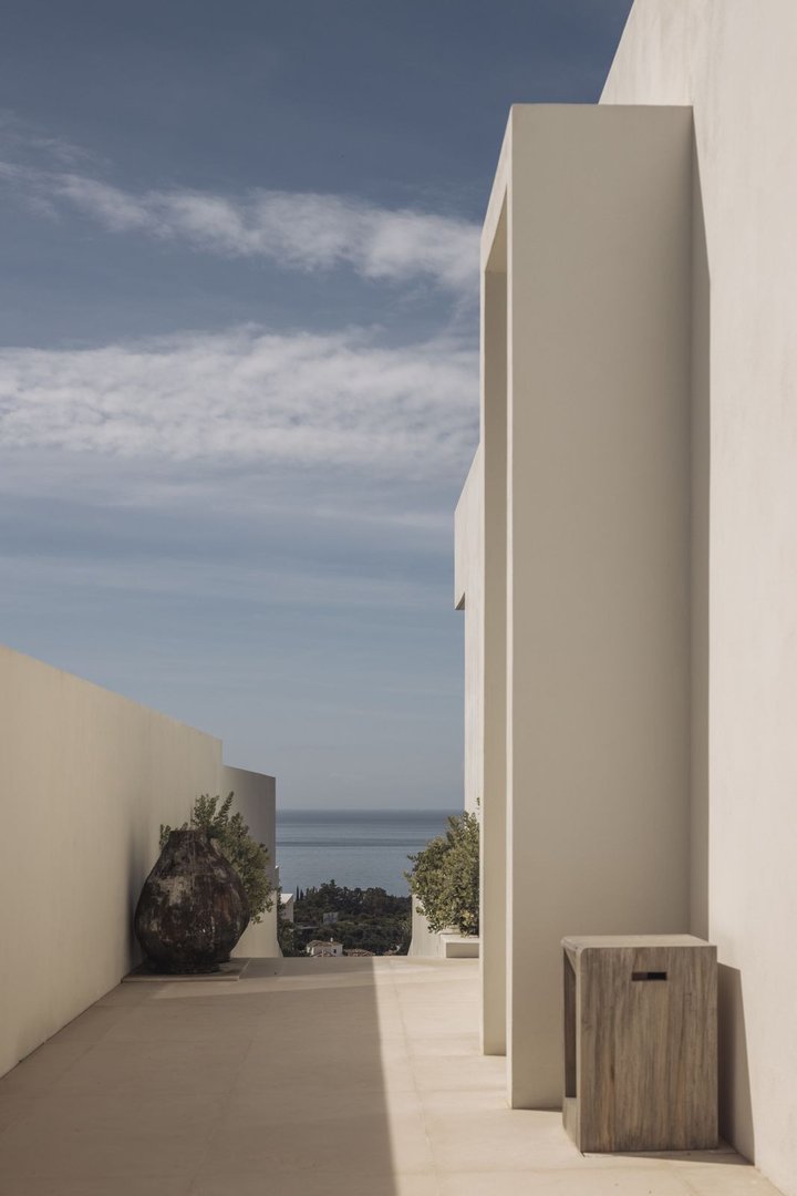 Modern outdoor terrace with a sea view, featuring minimalist architecture and decorative elements.