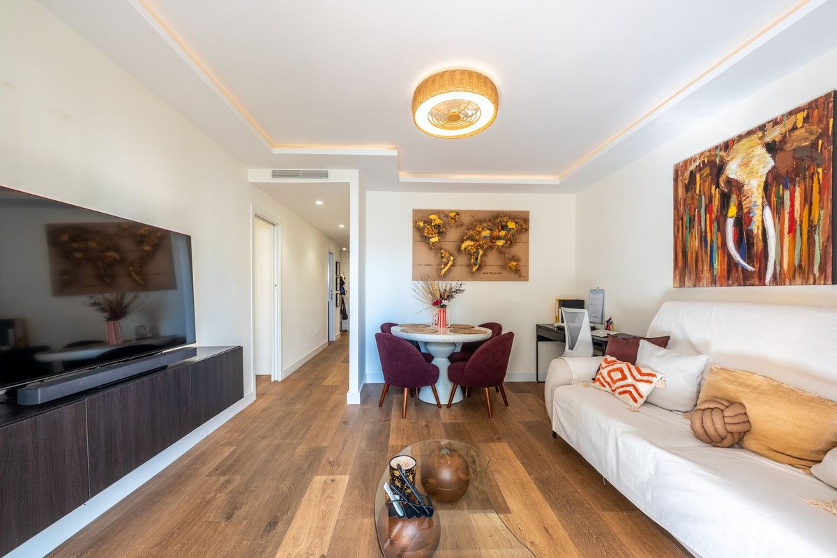 Modern living and dining room with world map art, elephant painting, and comfortable sofa. Features wooden floors and contemporary furniture.