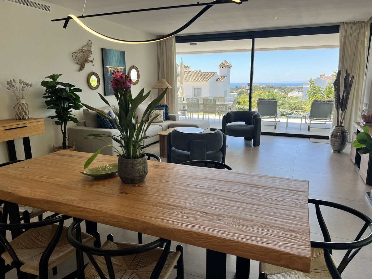 Spacious living and dining area with modern furniture, leading to a terrace with sea and landscape views.