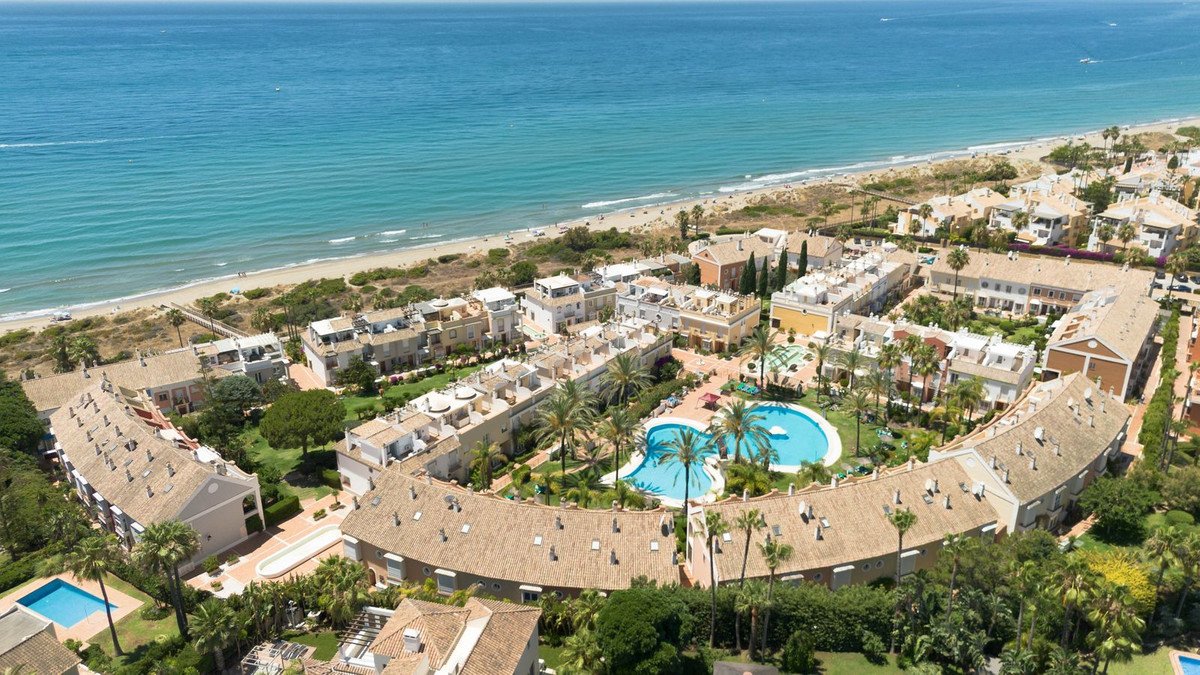 Aerial view of a beachfront resort with swimming pools and ocean view