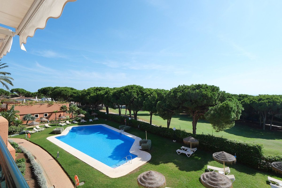 Balcony view of apartment with swimming pool and lush green garden