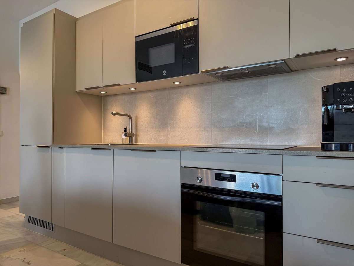 Modern kitchen with built-in oven, microwave, and sleek cabinetry.