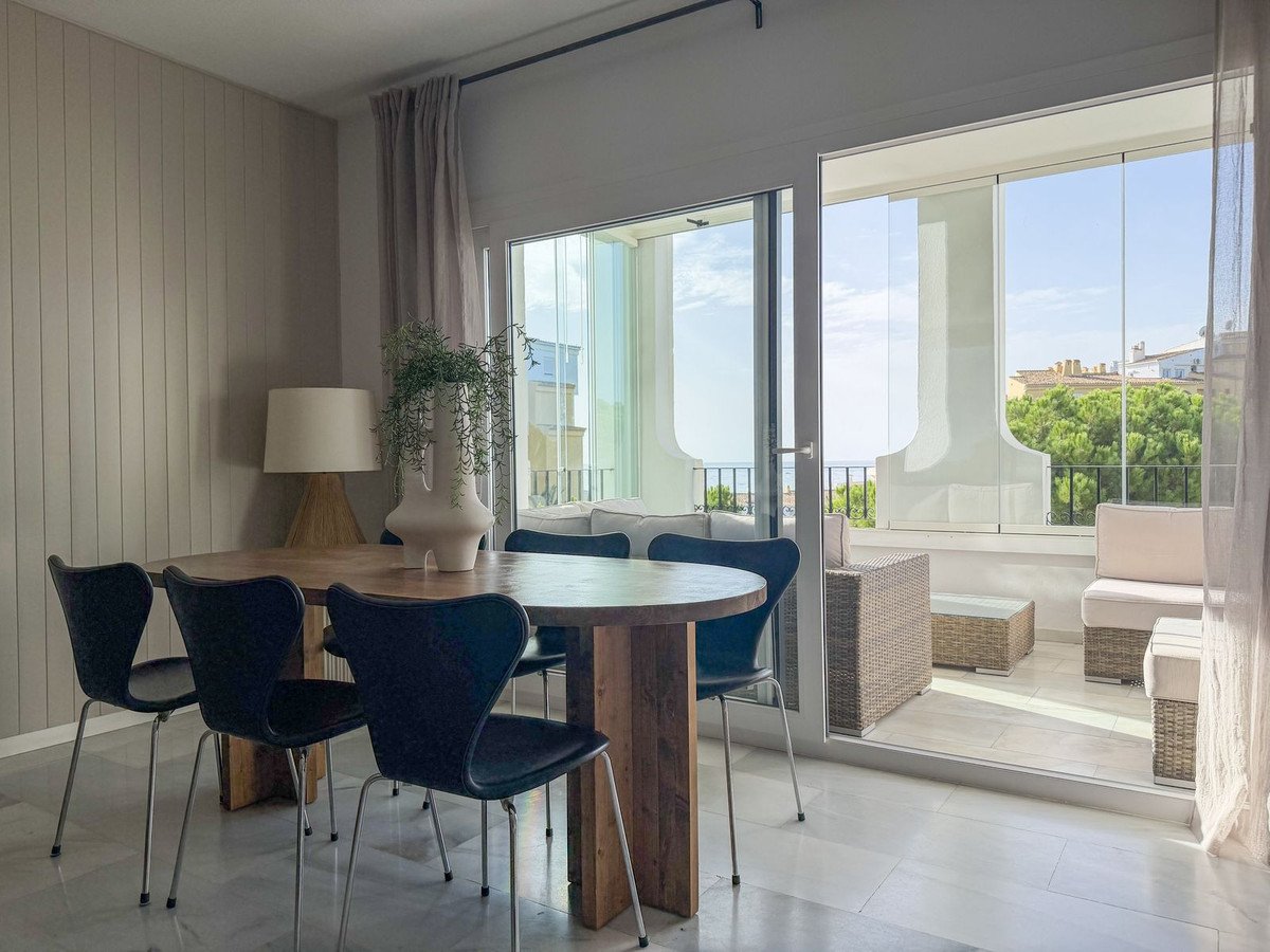 Dining room with sliding glass doors opening to a balcony with outdoor seating