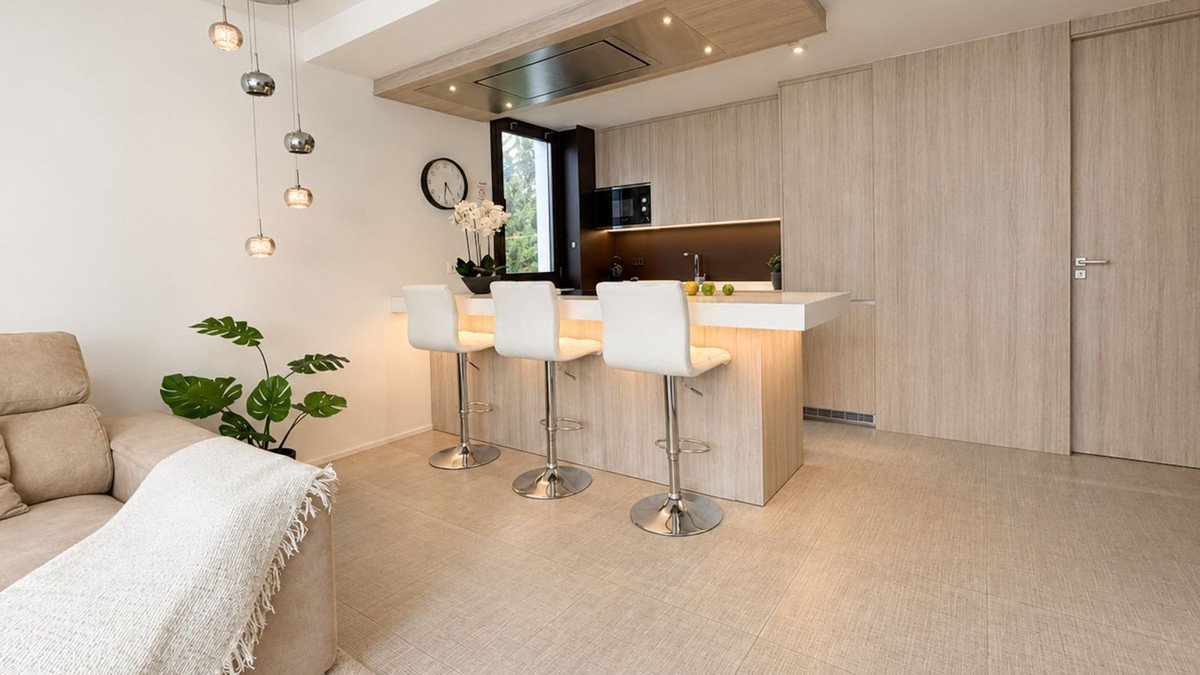 Modern open-plan living area with kitchen island and bar stools