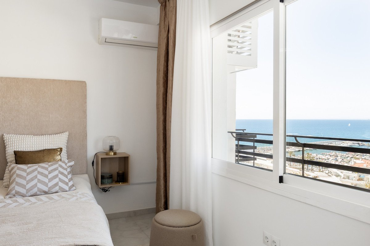 Cozy bedroom with large window overlooking the sea and marina