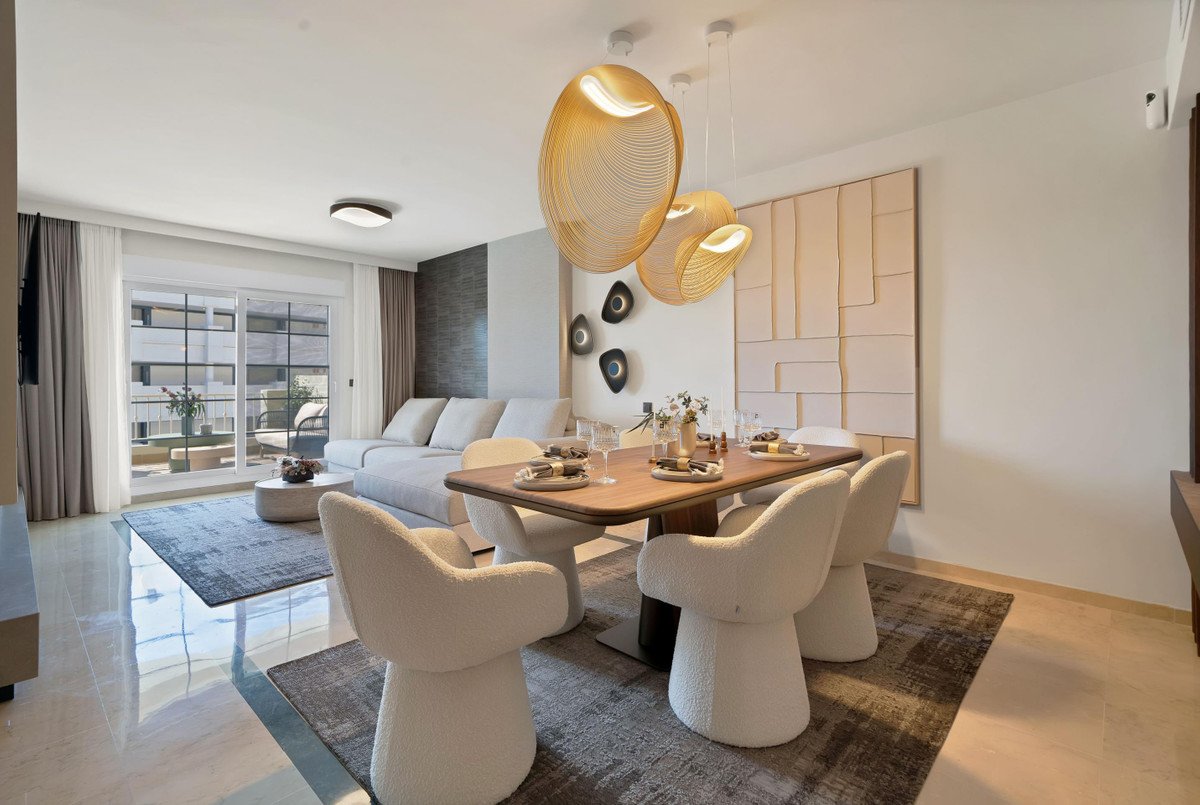 Modern living and dining area with white furniture, wooden table, and balcony view.