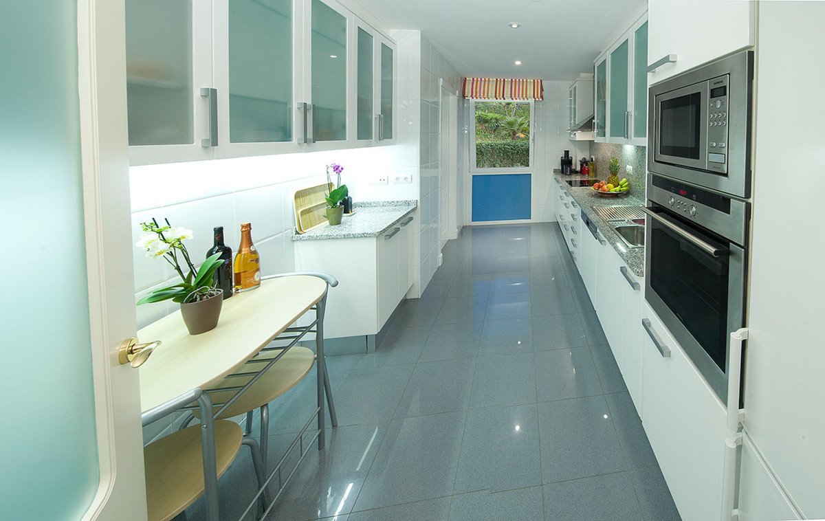 Modern kitchen with L-shaped counter, stainless steel appliances, and a dining area