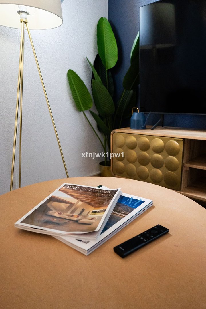 Living room table with magazines and a television